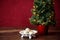 Christmas treat, white dish with Russian Tea Cake cookies on dark wood table with artificial Christmas tree with white lights, red