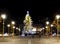 Christmas tree adorned with lights, surrounded by pillars with star shaped bulbs at