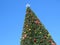 Christmas tree against blue sky. Happy festive joyous mood. New year celebration. Special occasions wallpaper or greeting card.