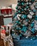 Christmas tree with blue balls ornaments and decorations at home with wrapped gift boxes