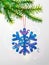 Christmas tree branch with knitted snowflake symbol