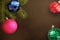 Christmas tree branch with pink, blue, red wavy and green ribbed ball on a dark background