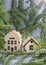 Christmas tree branches with mini houses on gray background