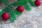 Christmas tree branches, red balls on winter snowbound wooden ba