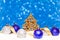 Christmas tree and candy in snow on blue glitter