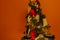 Christmas tree decorated with covid19 face masks on an orange background. Symbolic for a different christmas