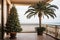 A Christmas tree is decorated on the hotel by the sea view on vacation in a tropical country with palm trees at sunset. Travel for