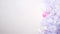 Christmas tree decorated in white silver and pink tones is shining with garlands on white background.