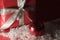 Christmas tree decoration behind a wrapped gift surrounded by artificial snow