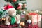 Christmas tree and decorations on the black table. Teddy bear in santa hat, gift box and New Year decor