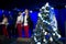 Christmas tree in decorations. Celebratory concert in blurred background