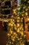 Christmas tree and garland outdoors on city street with bokeh lights strung across between buildings in Athens Greece