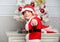 Christmas tree ideas for kids. Boy kid dressed as cute elf magical creature white artificial ears and red hat near