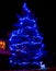 Christmas tree illuminated with blue LEDs in the garden