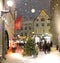 Christmas tree illuminated on evening winter in medieval city street ,lantern light blurred in shop windows vitrines , night sky f