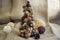 Christmas tree made of autumn ripened brown fruits on jute beige background, chestnuts cones beech nuts almonds walnuts peanuts