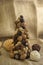Christmas tree made of autumn ripened brown fruits on jute beige background, chestnuts cones beech nuts almonds walnuts peanuts