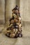 Christmas tree made of autumn ripened brown fruits on jute beige background, chestnuts cones beech nuts almonds walnuts peanuts