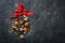 Christmas tree made of chocolate truffles, hazelnuts, anise stars, decorations, spoons and powdered sugar snow on dark background.