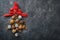 Christmas tree made of chocolate truffles, hazelnuts, anise stars, decorations, spoons and powdered sugar snow on dark background.