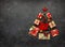 Christmas tree made from Christmas gifts and decorations on black background. Creative winter holiday concept. Flat lay