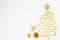 Christmas tree made of gold bead garland with decorations on white background.