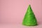 Christmas tree made of green threads on pink background