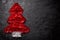 Christmas tree made from red tinsel christmas garland decoration on black stone background. Free space for your text
