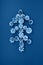 Christmas tree made of white painted pine cones on a blue background.