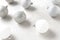 Christmas Tree Ornaments closeup with shallow depth of field. White and silver balls on a light gray table top