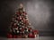 A christmas tree with ornaments and presents in front of a grey wall. Copy space, place for text