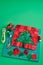 Christmas tree patchwork block, bright square pieces of fabric, pincushion, quilting and sewing accessories on craft mat, green