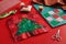 Christmas tree patchwork block, craft mat, bright square pieces of fabric, pincushion like Santa and quilting accessories on red