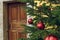 Christmas tree red balls toy rustic holidays decoration in poor ghetto back street district area with wooden entrance door