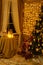 Christmas tree is in the room on the wall hanging garlands, a table by the window with candles