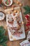 Christmas tree shape puff pastry cakes with chocolate filling, sugar powder and lollipops on wooden background. Christmas, New Yea