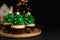 Christmas tree shaped cupcakes on black table. Space for text