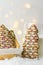 Christmas tree shaped shortbread cookies decorated with chocolate icing multicolored sugar sprinkles in basket glass of milk