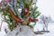 A Christmas tree stands decorated with garlands and tinsel in a snowdrift on a street in the Russian city in the courtyard