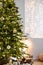 Christmas tree in stylish winter holiday interior with stars, lights, gifts and decoration. Xmas interior design template