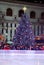 A Christmas tree towers above an ice rink