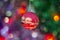 A Christmas tree toy ball on a background of multicolored tinsel