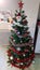 Christmas tree with white balls, snowflakes, golden bulbs and red garlands
