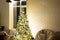 Christmas tree in white interior of a house with loft-style brick walls with garlands of glass toys on a rope. Glowing fairy