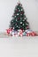 Christmas tree in the white room decor pine for the new year with postcard gifts