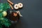 Christmas tree and wineglass of mulled wine with cookies and orange on the black table top view