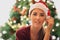 Christmas tree, woman and holiday celebration portrait with a young model in santa hat to celebrate Christian tradition