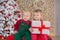 Christmas two children boys posing in studio shoot close to new year tree wearing velvet green and red clothes