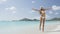 Christmas vacation travel woman jumping on beach wearing santa hat