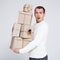 Christmas or Valentine`s day concept - handsome man in white warm sweater holding heap of gift boxes over gray background